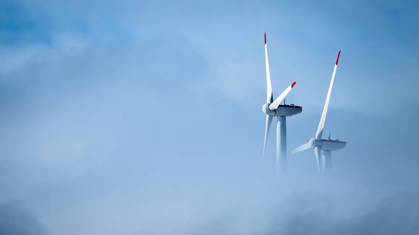 Two wind turbines partly hidden by clouds.